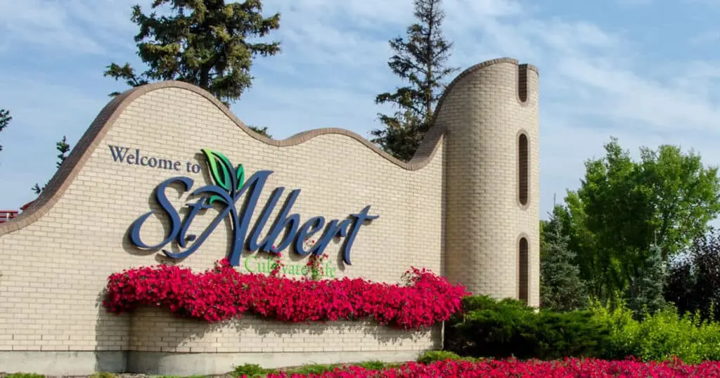 Welcome sign at the entrance of St. Albert, Alberta, featuring vibrant flowers and lush greenery.