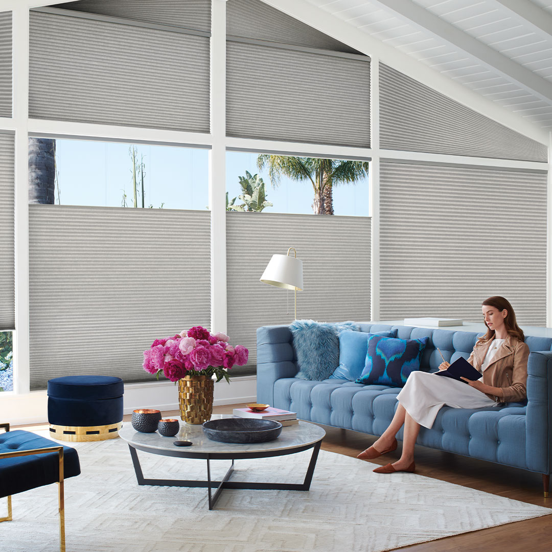 Woman sitting in room with Top-Down Bottom-Up on Applause Honeycomb Shades