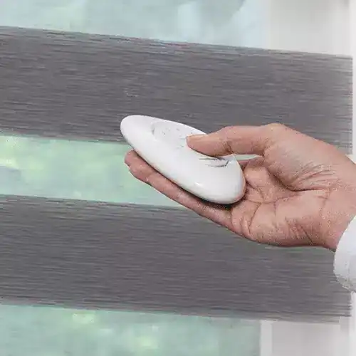 A close-up of a hand sanding a wooden wall with a handheld sander for smooth finish.