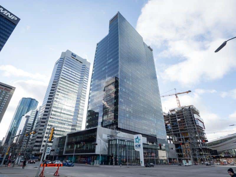 Brightly lit glass office building with reflective windows in a downtown area.