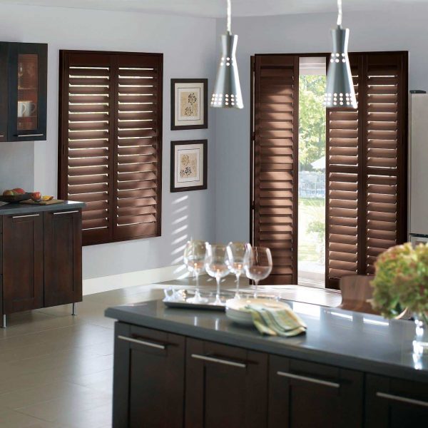 Dark wooden window shutters in modern kitchen with natural light streaming in.